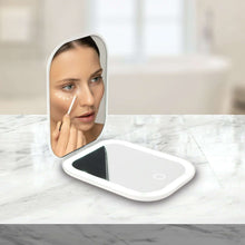 LED double-sided compact mirror used at vanity, person holding the open mirror