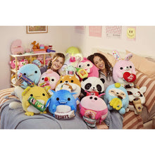 Unicorn Snackles plush toy with pink horn, rainbow body, shown among assorted plush toys