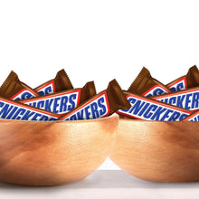 Snickers chocolate candy bars piled in two wooden bowls