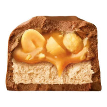 Milk chocolate candy bar cross-section with peanut pieces and creamy caramel