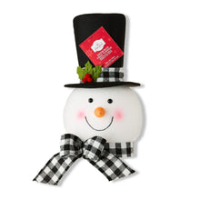 Snowman tree topper with black hat, plaid scarf, and red tag