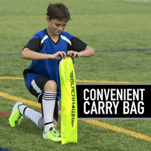 Child carrying a neon yellow soccer goal carry bag next to a pop-up goal