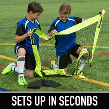 Two children unfolding a neon yellow soccer goal net from a carry bag