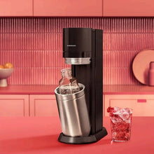 Sparkling water maker with stainless steel carafe and bottle filled with sparkling water