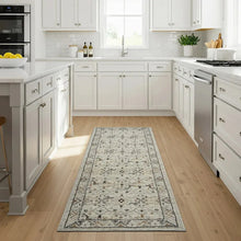 Ivory runner rug with distressed geometric and floral motifs in black and rust accents.