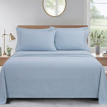 Microfiber sheet set with solid blue design, flat sheet and pillowcases on a bed