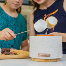 Solo Stove fire bowl on wood base with marshmallows roasting over the flame