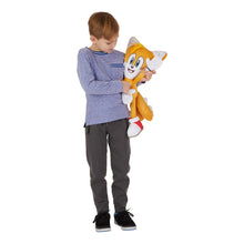 Child holding an orange Sonic plush cuddle pillow buddy with white collar and red shoes