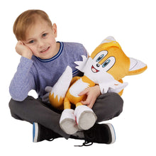 Child hugging an orange Sonic plush cuddle pillow buddy with white gloves and red shoes
