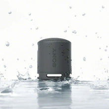 Dark gray water-resistant portable Bluetooth speaker with splash effect