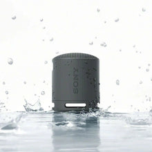 Dark gray portable Bluetooth speaker with water-splash protection and textured body