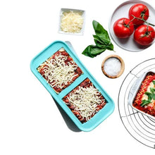 Turquoise silicone freezer storage tray with two rows of compartments, filled with food
