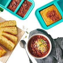 Turquoise silicone freezer storage tray with square compartments, filled with food