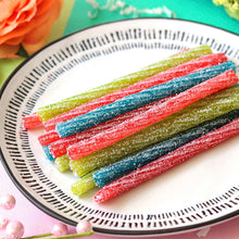 Sour Punch Twists candy sticks in red, blue, and green stripes on a plate