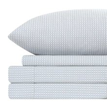 Folded white microfiber sheets with diamond pattern, layered with pillowcases