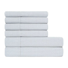 Stacked white microfiber sheets with diamond pattern, folded and ready