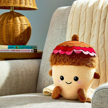 Plush acorn toy sitting with brown body, curly fur top, and pink-red scalloped cap