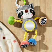 Plush raccoon clip-on toy with round yellow mirror and multicolor dangling arms