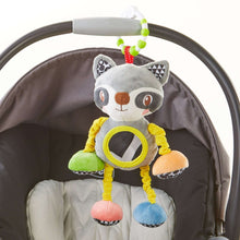 Clip-on plush raccoon toy attached to stroller with round yellow mirror