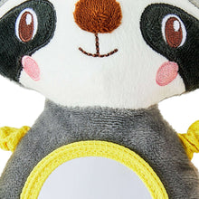 Close-up of plush raccoon face with round yellow mirror on its chest