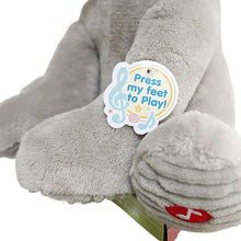 Grey koala plush foot with blue tag reading “Press my feet to Play.”