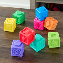 Scattered colorful numbered sensory stacking vinyl blocks with raised animal and symbol designs