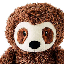 Close-up sloth plush toy face with curly brown fur, white mask, and stitched brown eyes