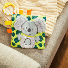 Koala taggie crinkle toy on textured fabric with plush face and ribbon tags