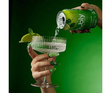 Green sparkling water mocktail can pouring into a clear glass