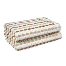 Tan bath towel set, folded, featuring a dotted grid pattern and soft terry texture