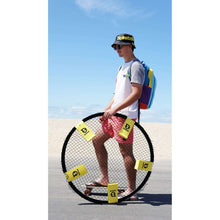 Spikeball net and yellow balls in use with person nearby