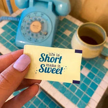 Single zero calorie sweetener packet held in a hand