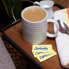 Zero calorie sweetener packets beside white coffee mugs
