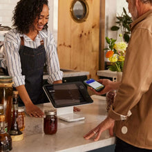 Square POS iPad stand on a counter with iPad screen and white pedestal base
