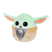Light green Grogu plush with tan armor trim, dark gray chest emblem, and smiling mouth
