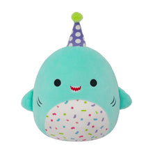 Teal shark plush with purple party hat and confetti belly, smiling face.