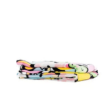 Folded throw blanket with multicolor cartoon faces and stripes; stacked three layers