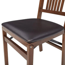 Wood folding chair with square dark seat cushion and slatted backrest