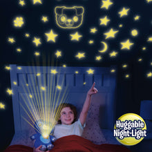 Blue plush puppy night light projecting stars and striped rays on a wall.