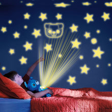Blue plush puppy night light projecting star and light rays in a bedroom.