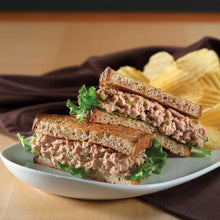 Chunk light tuna sandwich on toasted bread with lettuce and tomato on plate