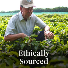Ground coffee with 'Ethically Sourced' text over a person in a field