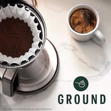 Coffee brewing setup with cup of dark coffee and metal carafe