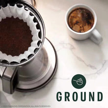 Coffee maker brewing ground coffee into a small cup