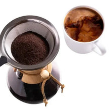 Ground coffee in portafilter basket with dark coffee in a small cup