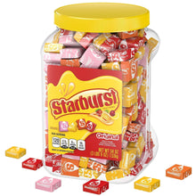 Starburst Original chewy candy jar with yellow lid and scattered wrapped pieces