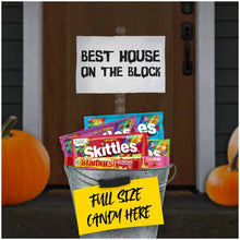 Starburst and Skittles candy packs in a container with fall decorations and notes.
