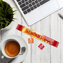Starburst Original single candy pack on a table beside a cup of coffee.