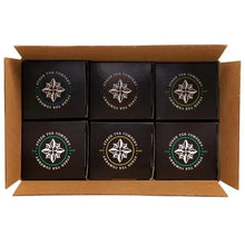 Assorted black tea tins with white logo, six tins in open box