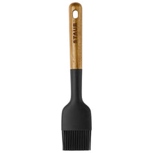 Kitchen silicone basting brush with black bristles and wood handle with hanging hole